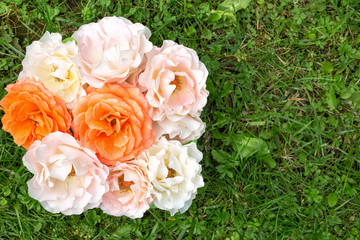 Bouquet of roses on a green grass, flat lay