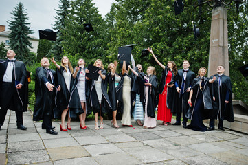 Happy university graduates throwing their graduation caps into the air.