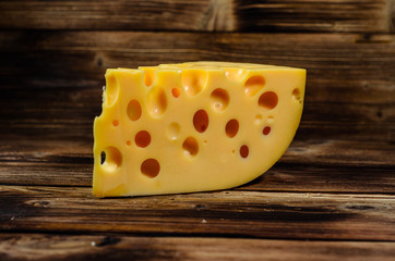 Piece of cheese on wooden table