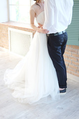 Fototapeta na wymiar Bride and groom embracing in sunlit room