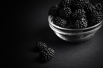 Fototapeta na wymiar Fresh Ripe Juicy Blackberries in a plate on black background