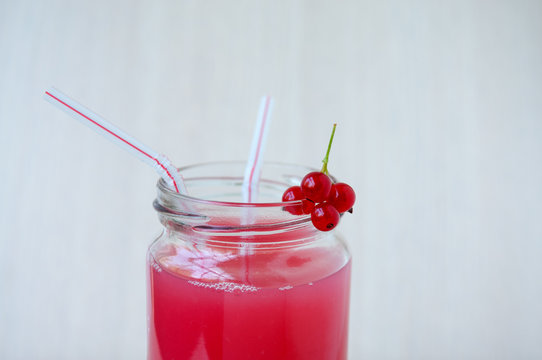 On beige background, a red currant drink