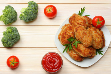 Homemade cutlets with tomato and broccoli on a wooden table. Healthy food. top view with copy space