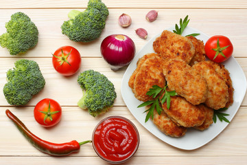 Homemade cutlets with tomato and broccoli on a wooden table. Healthy food. top view with copy space