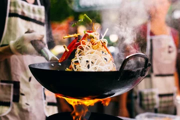 Foto op Canvas Man cooks noodles on the fire © IVASHstudio