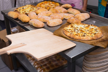 hot cooked Italian pizza with cheese, mushrooms and tomato sauce on a table. Cooking concept, cooking time, selective focus