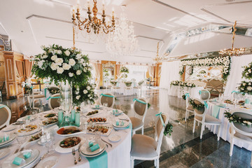 Dinner tables with mint clothes decorated with white roses