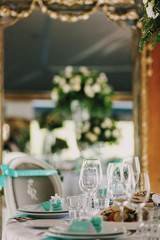 Mirror reflects vase with white roses on a dinner table