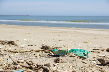 Fototapeta na wymiar Polluted beach. Discarded plastic bottles and wastes on a beach .