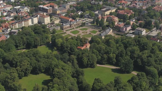Aerial of green landscape and birds eye view of the city Gotha in Germany, drone view over the historical castle "Schloss Friedenstein", 4K