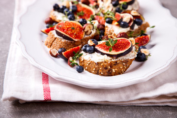 Bruschetta with cheese, figs , thyme and berry blueberrie with honey.Snack a sandwich with cream cheese.selective focus