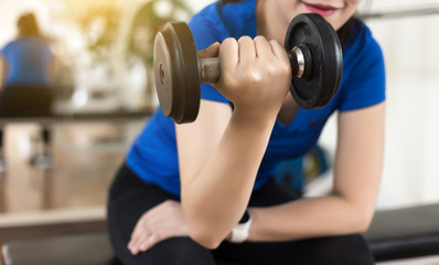 woman fitness  workout use dumbbell in Closeup on fitness training Strong Female fitness exercise concept