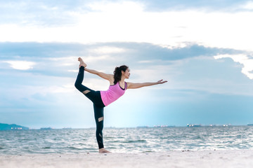 Fototapeta premium Young asian yoga exercise with posting on the beach in summer outdoor
