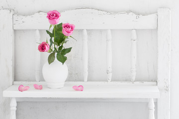 pink rose on white wooden shelf