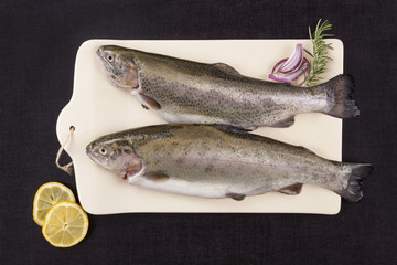 Fresh trout fish on chopping board.