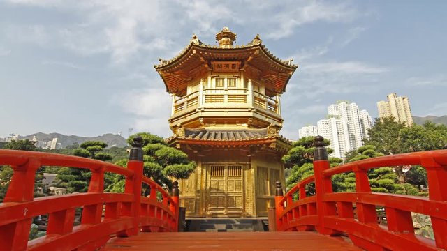 Red Wooden Arch Bridge and Golden Pavilion in Nan Lian Garden, Hong Kong. - 4K zoom out