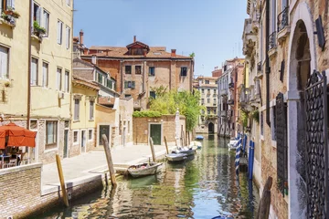 Tuinposter Venice as it is: canal, gondolas, bright buildings and tourists at noon time. © juhrozian