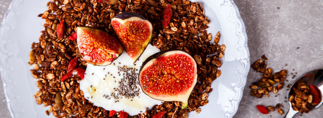 Granola with fresh figs and honey. Breakfast on the gray background.Food or Healthy diet concept.Top View. selective focus.