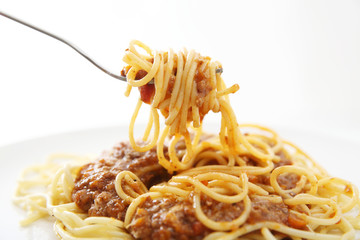 Spaghetti bolognese with fork isolated in white background