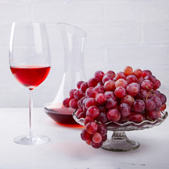 Wine Pink and Grape bunch. Alcoholic drink in a glass glass on a light background.Copy space for Text.  selective focus.