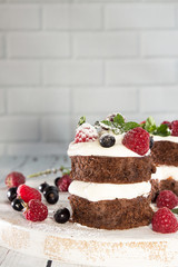 Chocolate cake decorated with raspberry, wipped cream, chocolate sauce and mint.