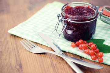 red currant jam and  ripe on wooden table