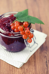 red currant jam and  ripe on wooden table