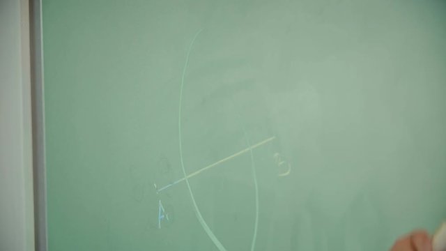 A young student is using a pair of compasses to draw something on a blackboard. She is showing how to solve a problem.