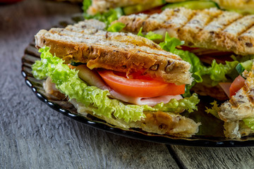 Panini sandwich with ham, tomato and lettuce.