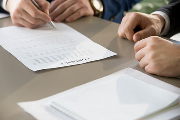 Businessman signing financial contract at formal meeting, male hand putting signature after...