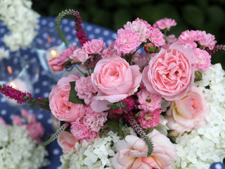Bouquet in a jug of white hydrangeas and pink roses. Festive table decoration.