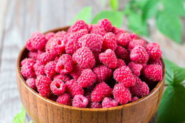 Fresh Raspberries in bowl on wooden table