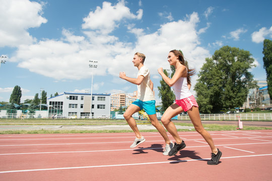 Couple running on arena track.
