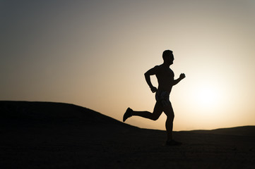 man running silhouette at sunset, young caucasian run in mountain
