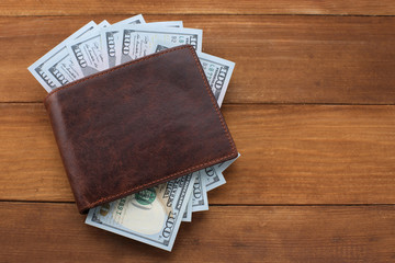 Wallet with money on wooden background