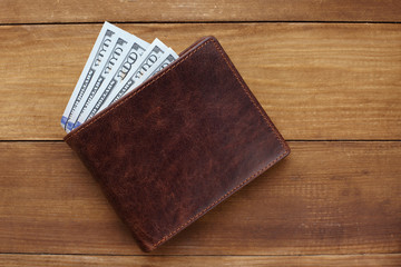 Wallet with money on wooden background
