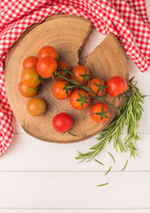 Organic cherry tomatoes with rosemary on rustic wooden table