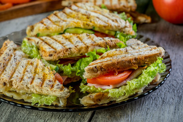 Panini sandwich with ham, tomato and lettuce.