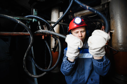 man in the underground mine repairs the hydraulic pipes. Concept work in difficult conditions.