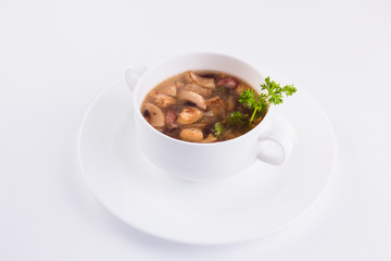Mushroom soup in a circular plate on a white background