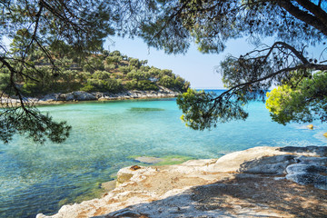 Fototapeta na wymiar Landscape image of meditteranean lagoon with beautifil blue green sea, rocks and evergreen trees