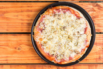 Flat lay above baked pizza on the wooden boards table