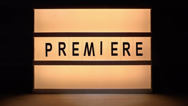 Vintage illuminated lightbox Premiere sign in cinema movie or for radio and television live audience broadcast