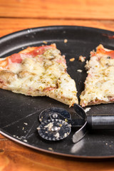 Sliced fresh baked pizza with mushrooms cheese ham ketchup on the round baking pan