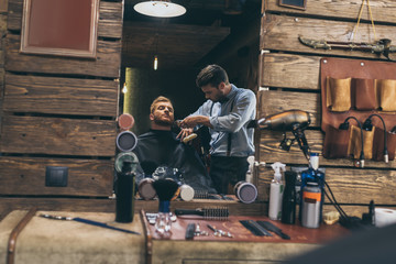 Fototapeta na wymiar barber trimming customers beard