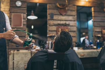barber applying perfumes to customer