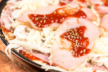 Slice of baked pizza with ham mushrooms ketchup in closeup macro view