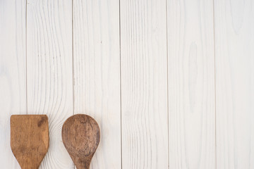 Wooden spoon and spatula on an old white table.