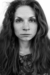 Black and white portrait of a curly girl in freckles