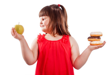 How to teach children to eat healthy food. Girl with food, chooses what to eat donuts or fresh...